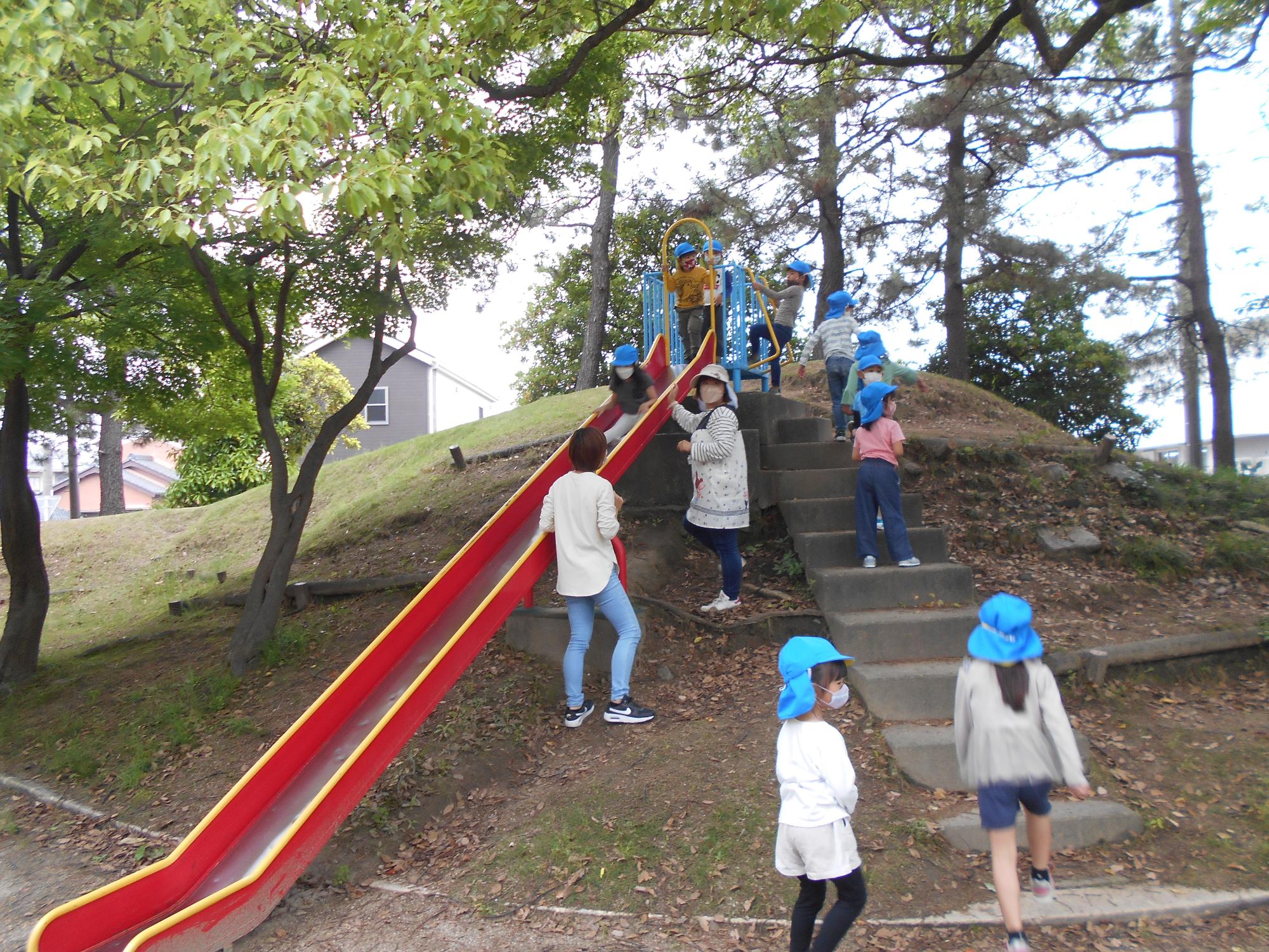 公園の滑り台で遊ぶ5歳児