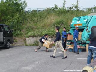 段ボールを回収車に運んでいる保護者の写真