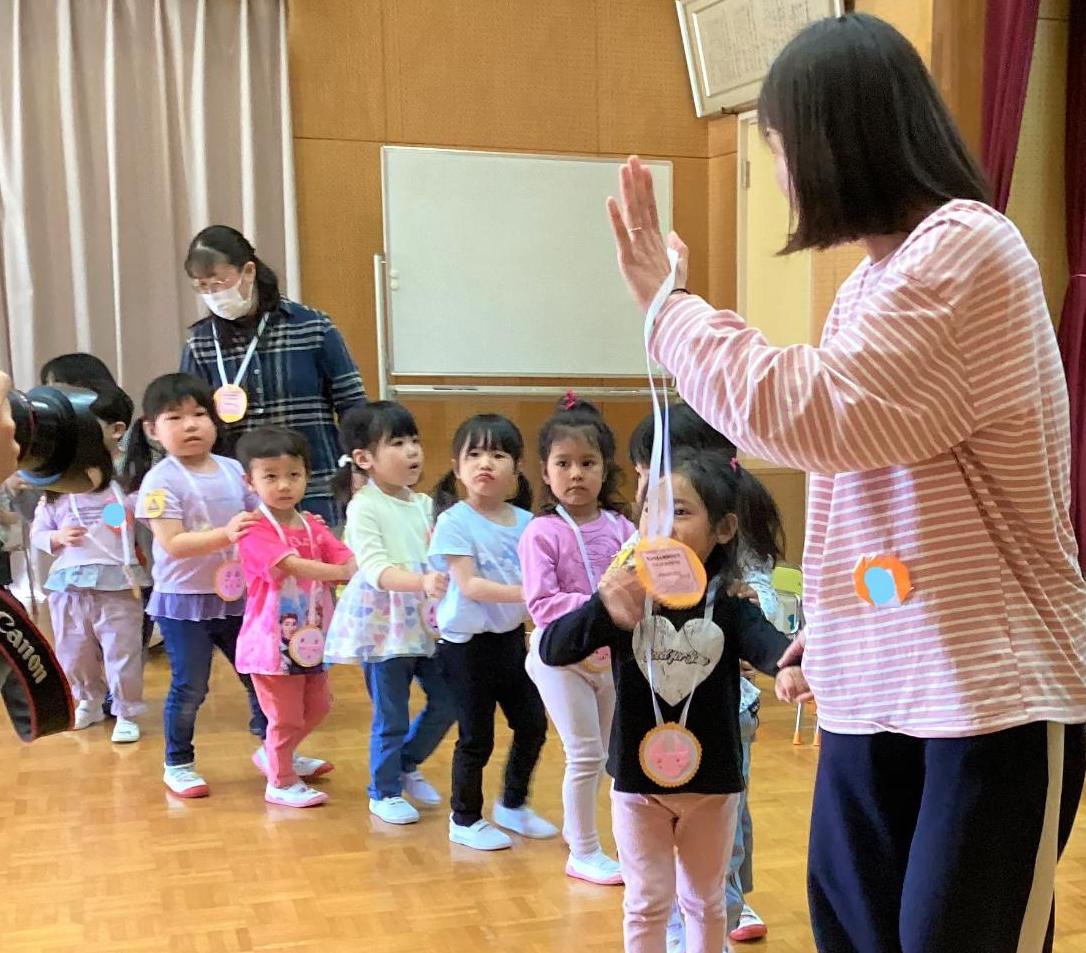 入園おめでとう会  お兄さんお姉さんからペンダントをもらってお部屋に帰ります。